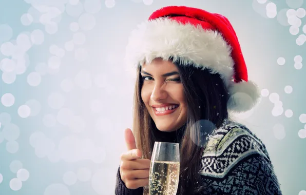 Girl, new year, a glass of champagne, winks, the Santa hat