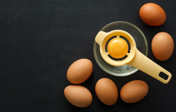 The dark background, eggs, spoon, bowl, the yolk, protein, chicken, separator