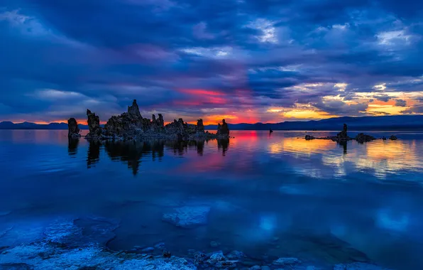 The sky, clouds, sunset, mountains, lake, stones, rocks, glow