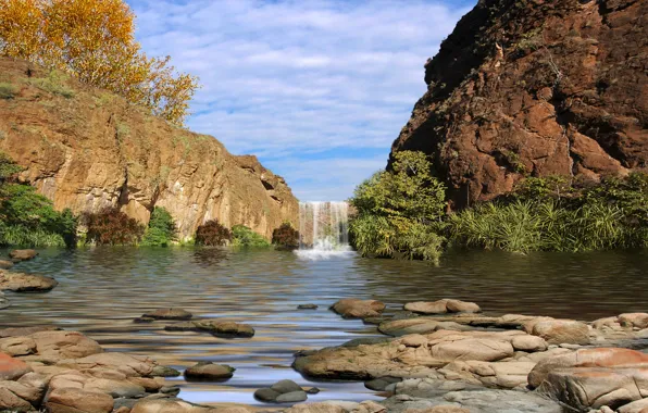 The sky, grass, leaves, clouds, trees, stones, rocks, waterfall