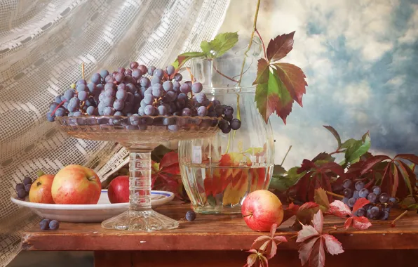 The sky, leaves, table, apples, grapes, curtains, pitcher, fruit