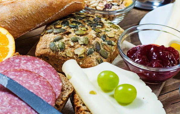 Orange, cheese, grapes, sausage, orange, grapes, jam, bread