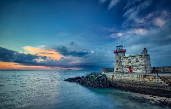Sea, clouds, stones, lighthouse, the evening