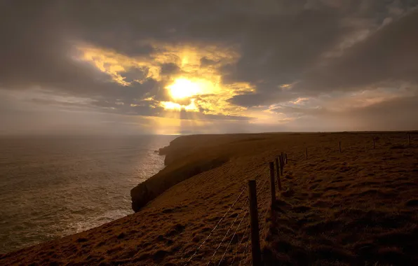 Sea, the sun, clouds, shore, fence