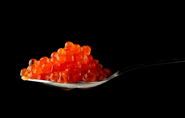 Picture spoon, black background, red caviar