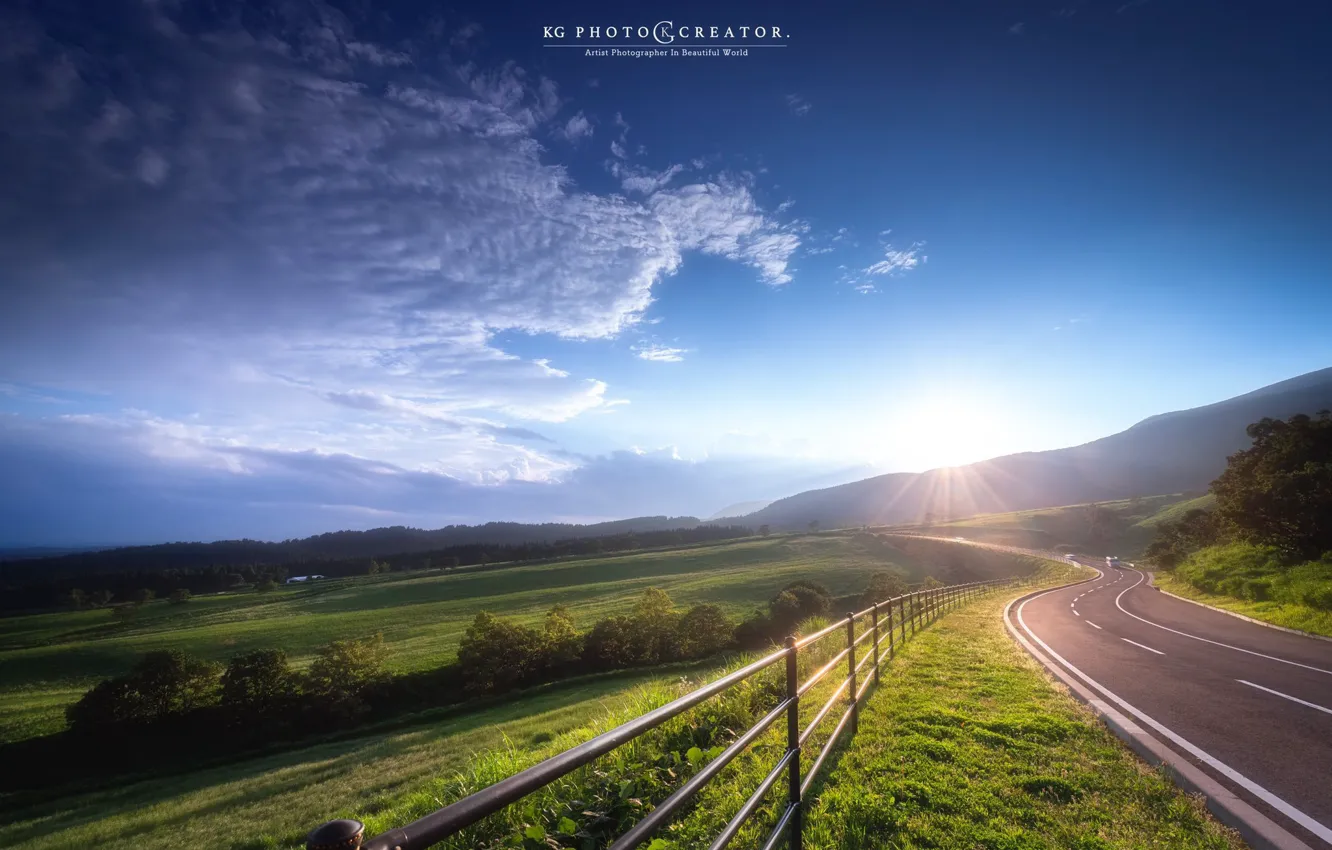 Photo wallpaper road, field, the sky, the sun, rays, trees, mountains, nature