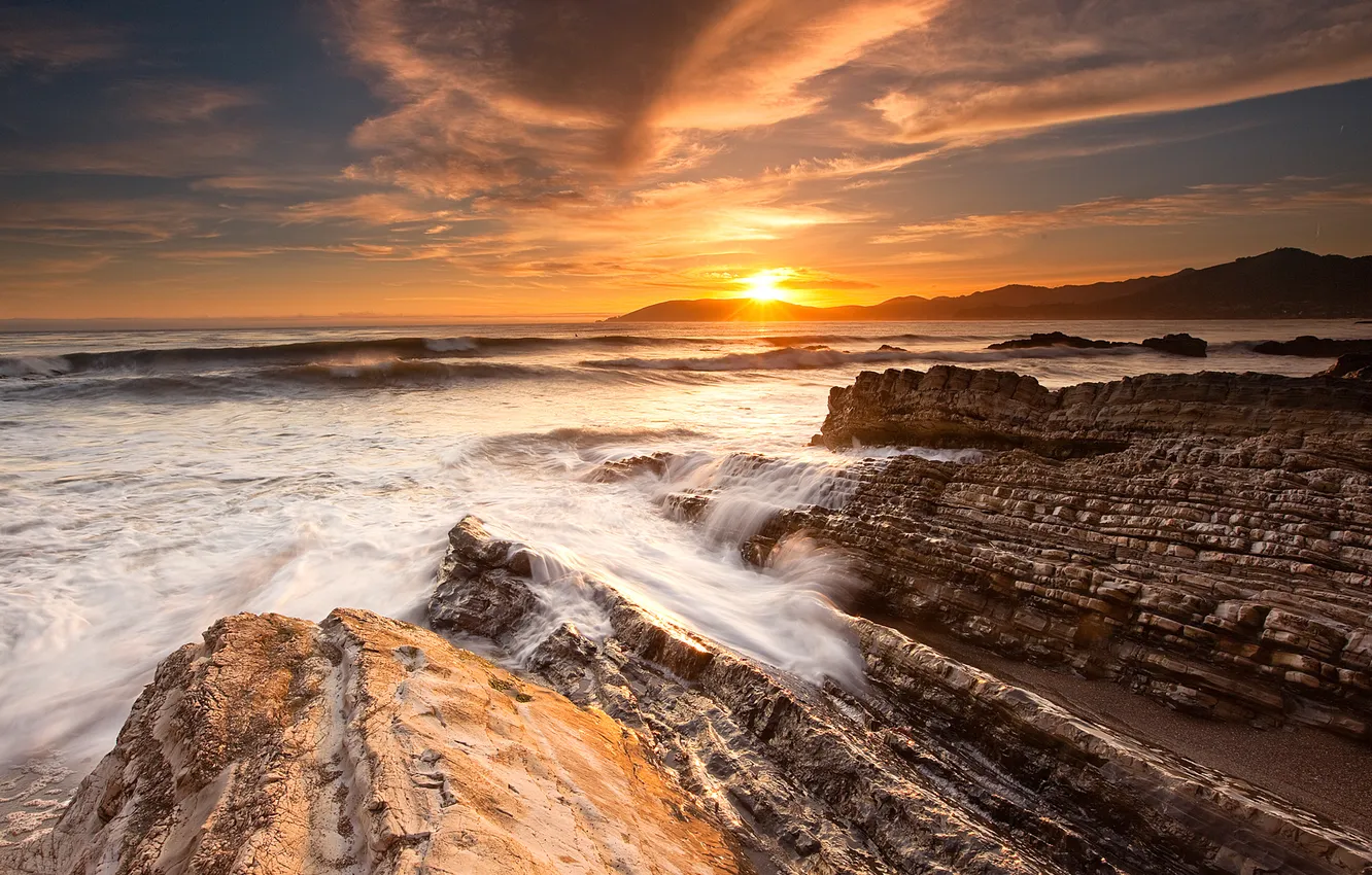 Photo wallpaper sea, wave, the sky, the sun, clouds, rays, stones, rocks