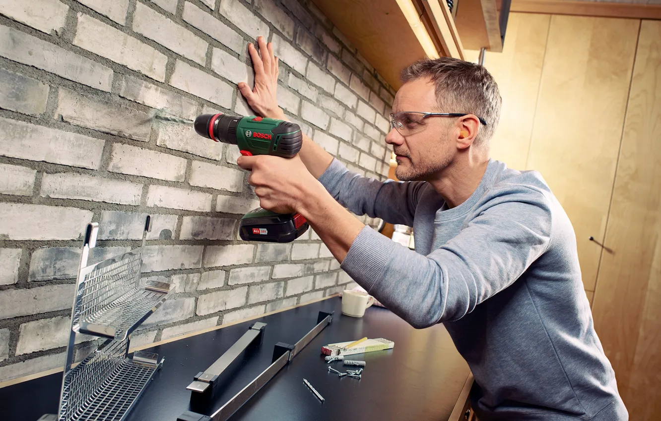 Photo wallpaper man, bosch, drill, brick wall