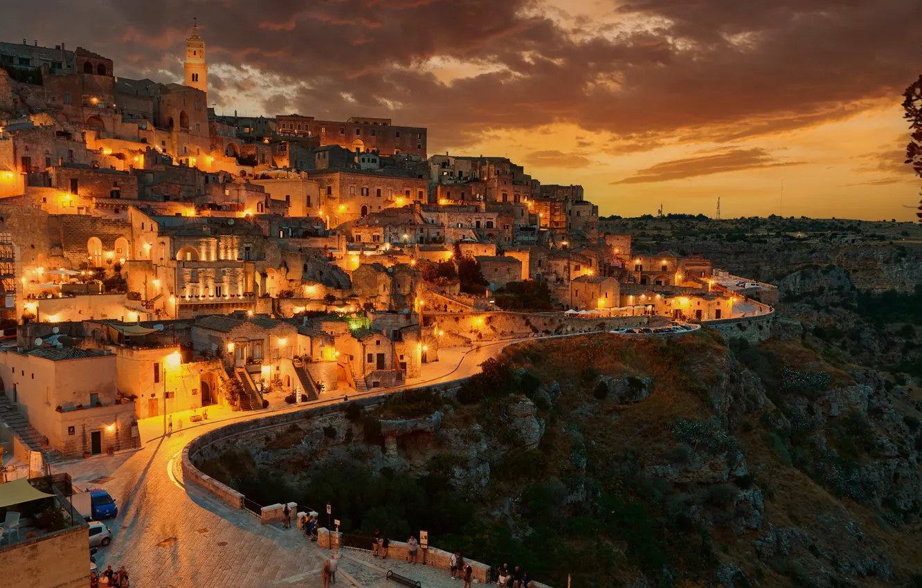 Photo wallpaper road, clouds, sunset, mountains, night, the city, lights, rocks