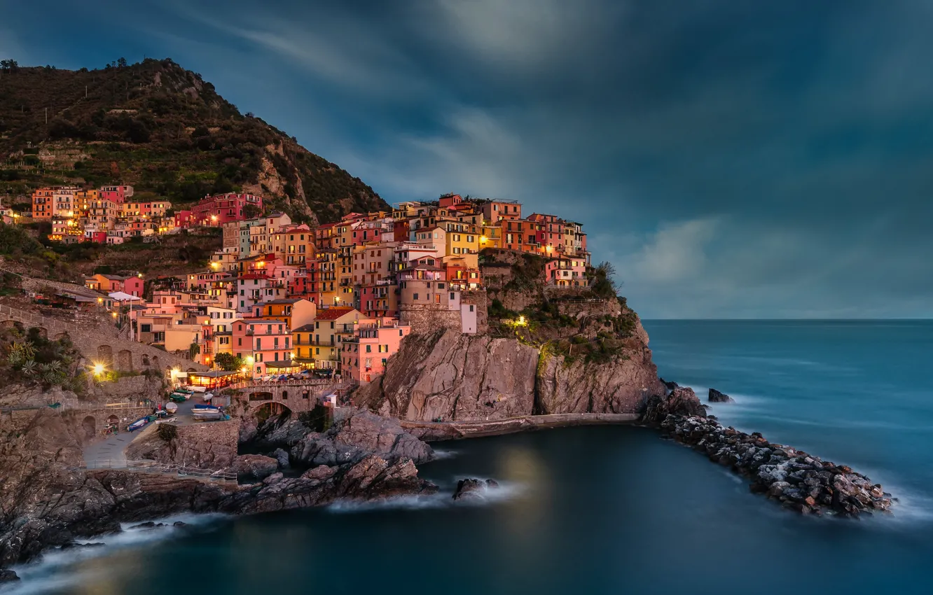 Photo wallpaper sea, clouds, the city, lights, stones, rocks, shore, building