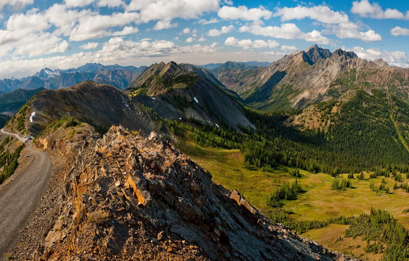 Photo wallpaper road, forest, the sky, clouds, mountains, stones, rocks, tops