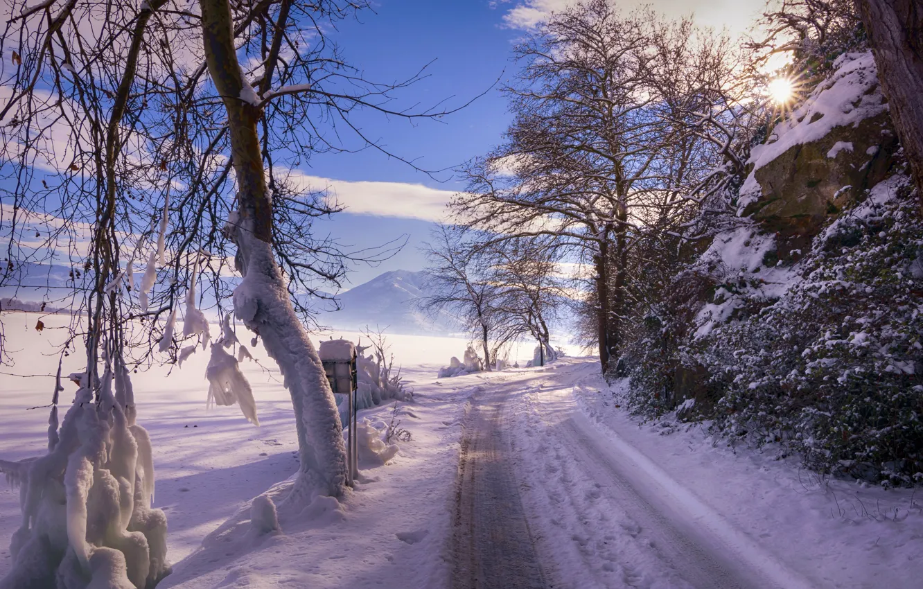 Photo wallpaper winter, road, field, the sky, the sun, clouds, rays, light