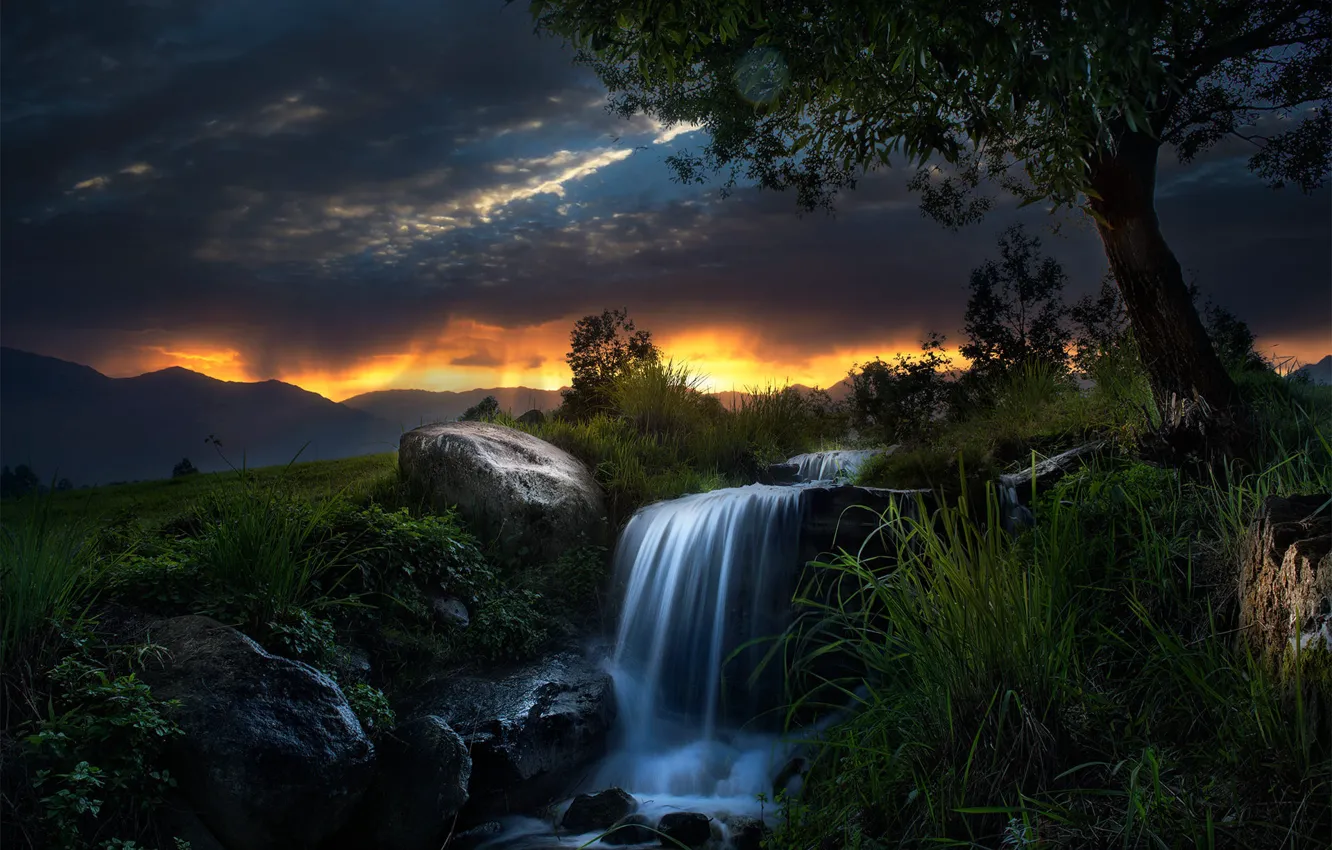 Photo wallpaper grass, sunset, mountains, clouds, stones, tree, waterfall, slope
