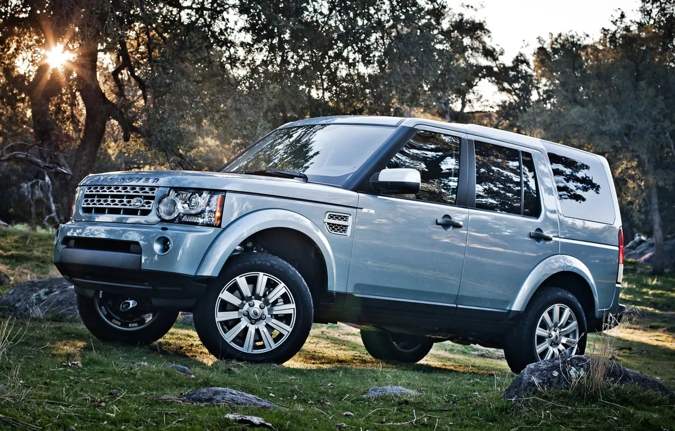 Photo wallpaper grass, the sun, trees, stones, jeep, SUV, Land Rover, the front