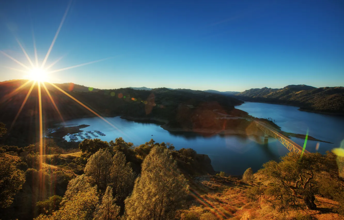Photo wallpaper the sky, the sun, rays, bridge, river, hills