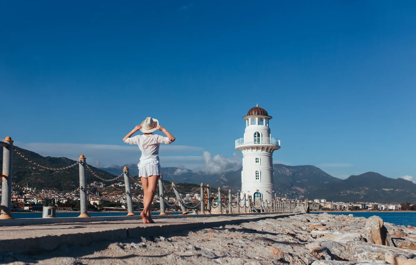Photo wallpaper sea, girl, landscape, mountains, shorts, lighthouse, hat, barefoot