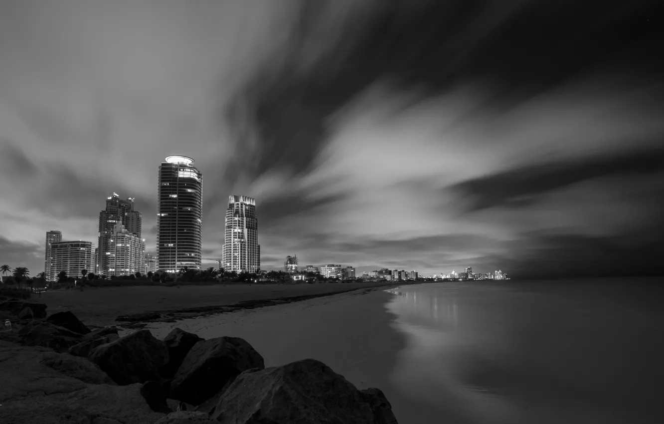 Photo wallpaper sea, beach, night, clouds, stones, shore, skyscrapers, excerpt