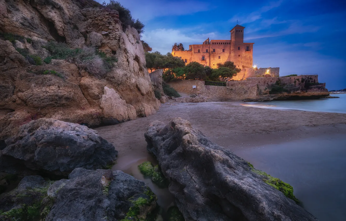 Photo wallpaper sea, lights, castle, rocks, shore, the evening