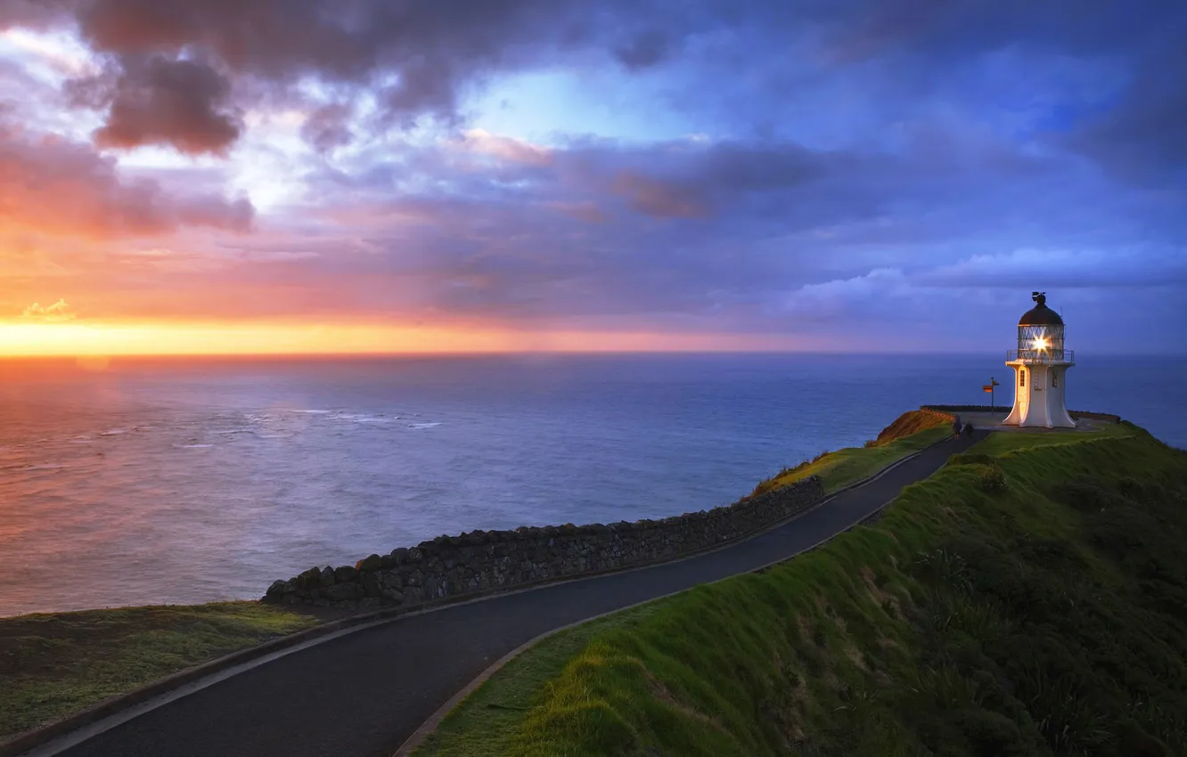 Photo wallpaper road, sea, grass, sunset, clouds, lighthouse, fence