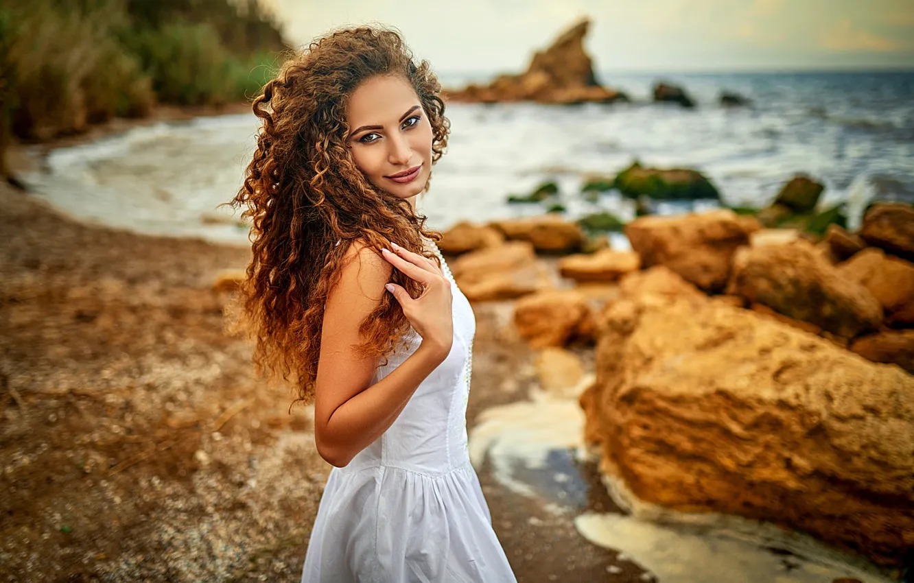 Photo wallpaper sea, look, girl, stones, shore, dress, brown hair, curls
