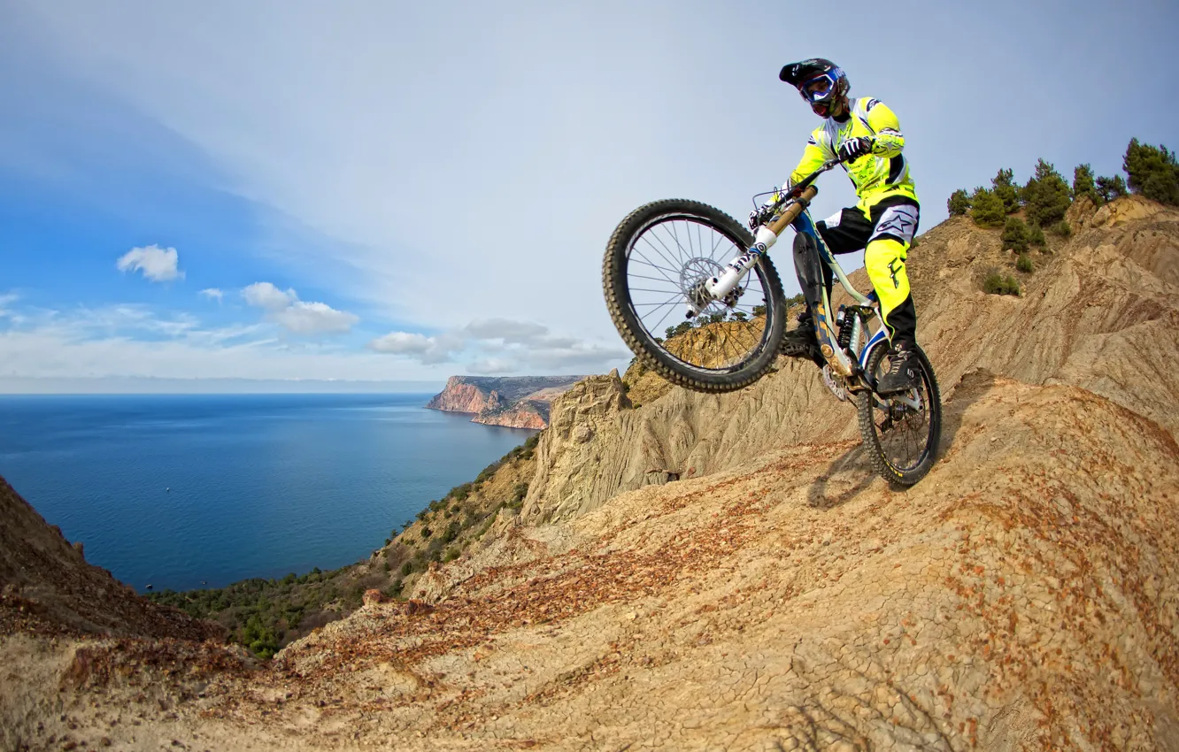 Photo wallpaper sea, mountains, bike, rocks, coast, costume, gloves, helmet