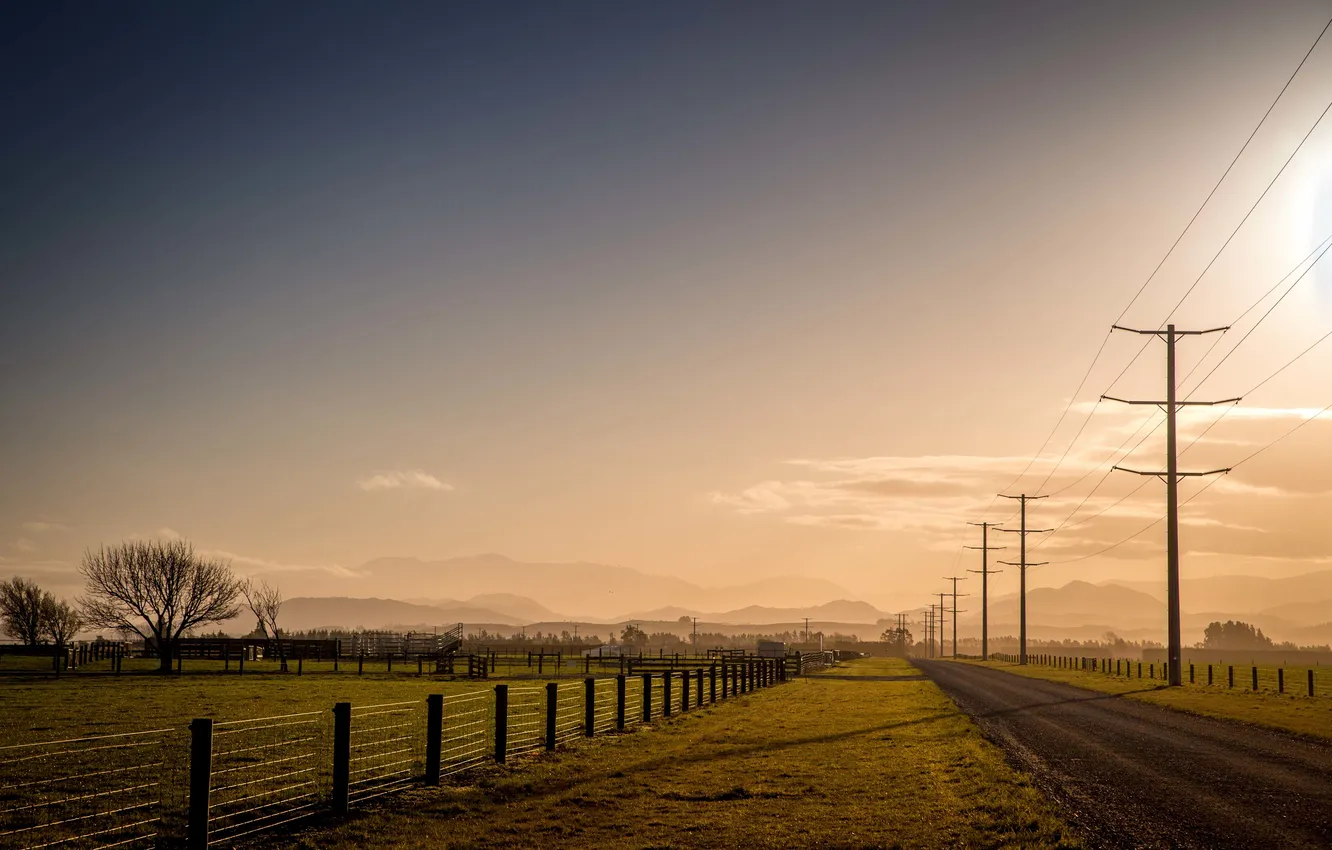 Photo wallpaper road, field, the sun, clouds, trees, hills, the fence, shadow